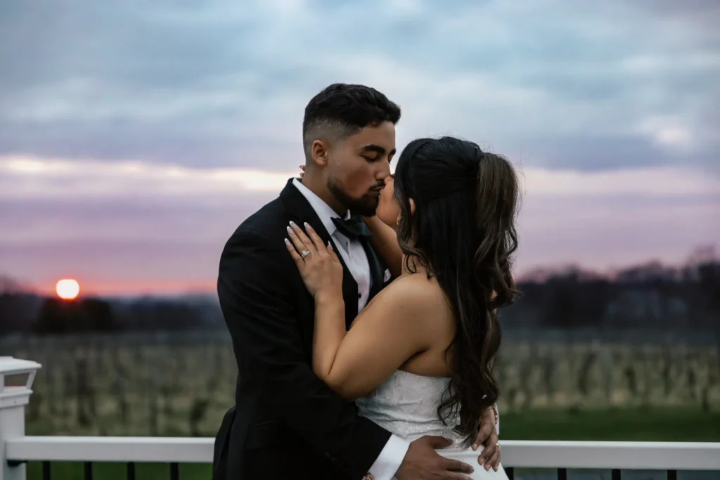 Bride and groom kissing at sunset in the vineyard at Casa Larga — golden hour romance in April 2025, photographed by Wolf Cry Productions.
